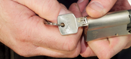 Close up van een los slot met sleutel vastgehouden door twee handen