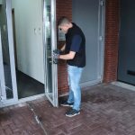 Een medewerker van Slotenmaker Expert gebruikt een boor om het oude slot uit een deur te halen.